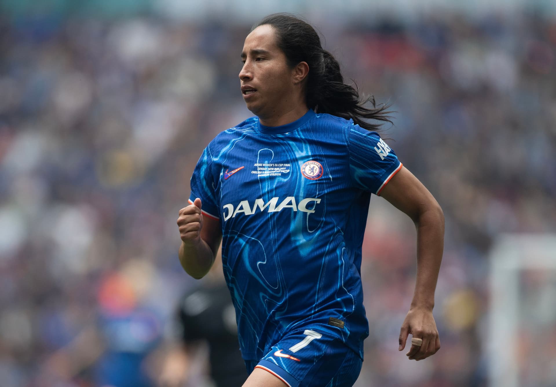 Mayra Ramirez running on the pitch wearing a Chelsea kit